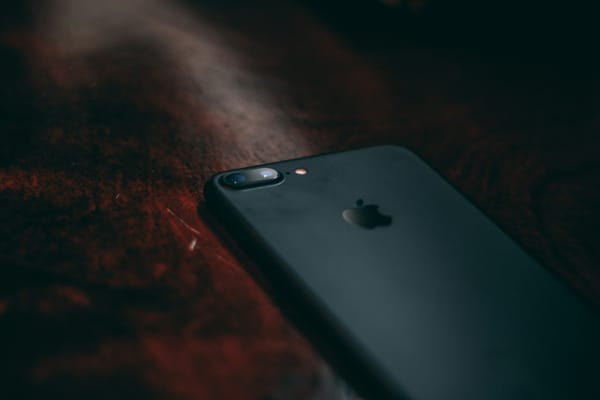 Iphone posé sur un table de bois sombre